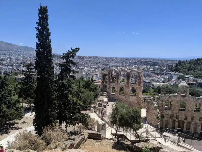 Roman theater nestled beneath the Acropolis, overlooking modern Athens